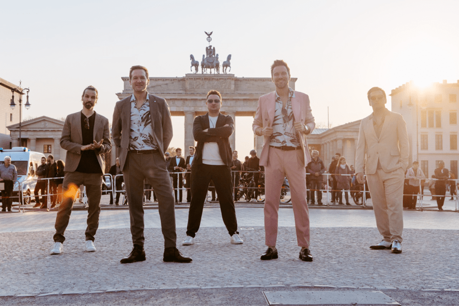 Alt Tag: Fünf Männer in lässigen Jackets posieren vor dem Brandenburger Tor